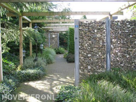 Moderne tuin met schanskorven, pergola en siergras