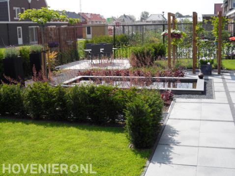Moderne tuin met gazon, vijver en houten pergola